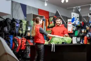 Woman with salesperson at the counter of sports shop